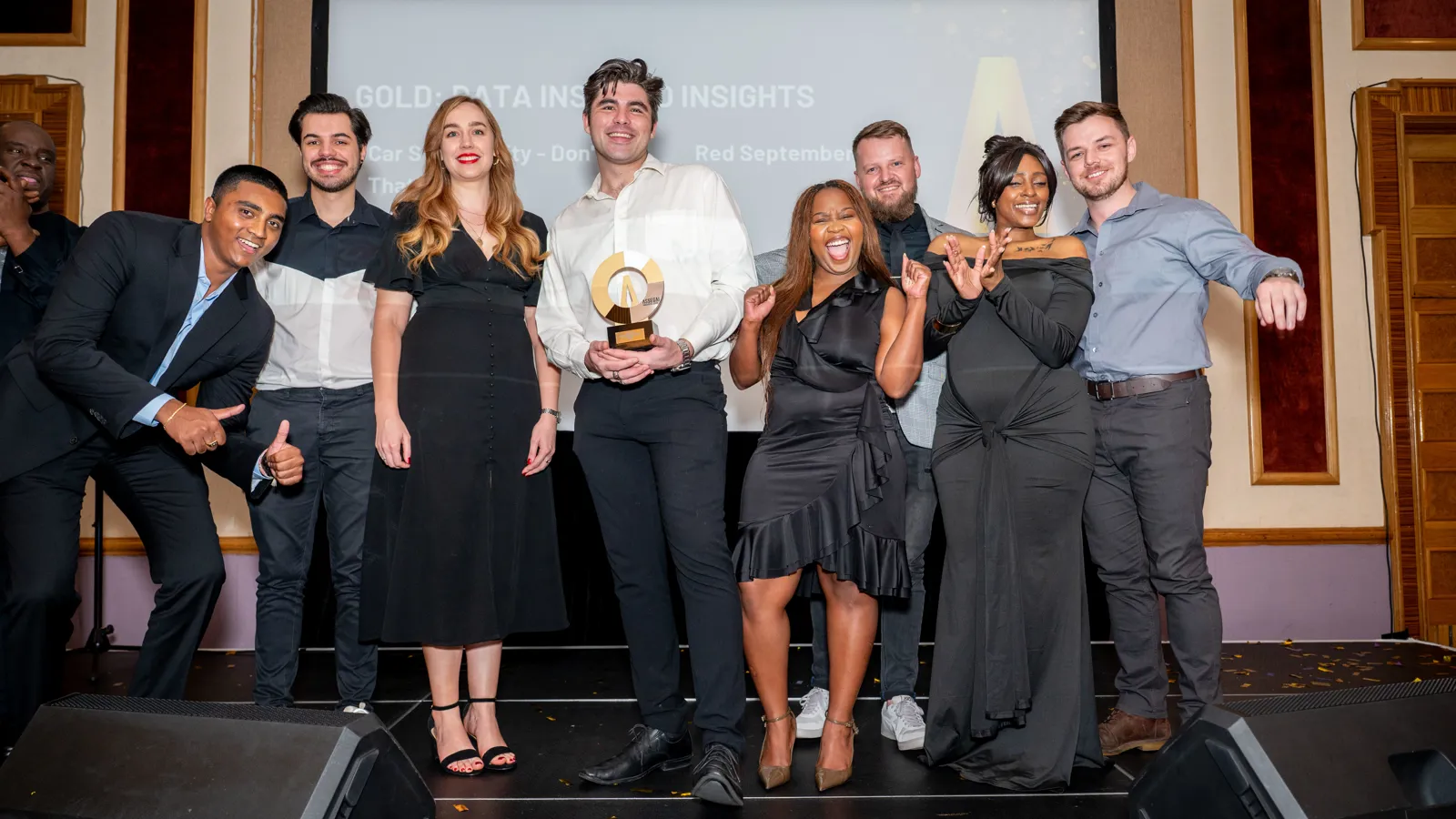 Team of Assegai Awards 2025 winners posing with their trophy on stage